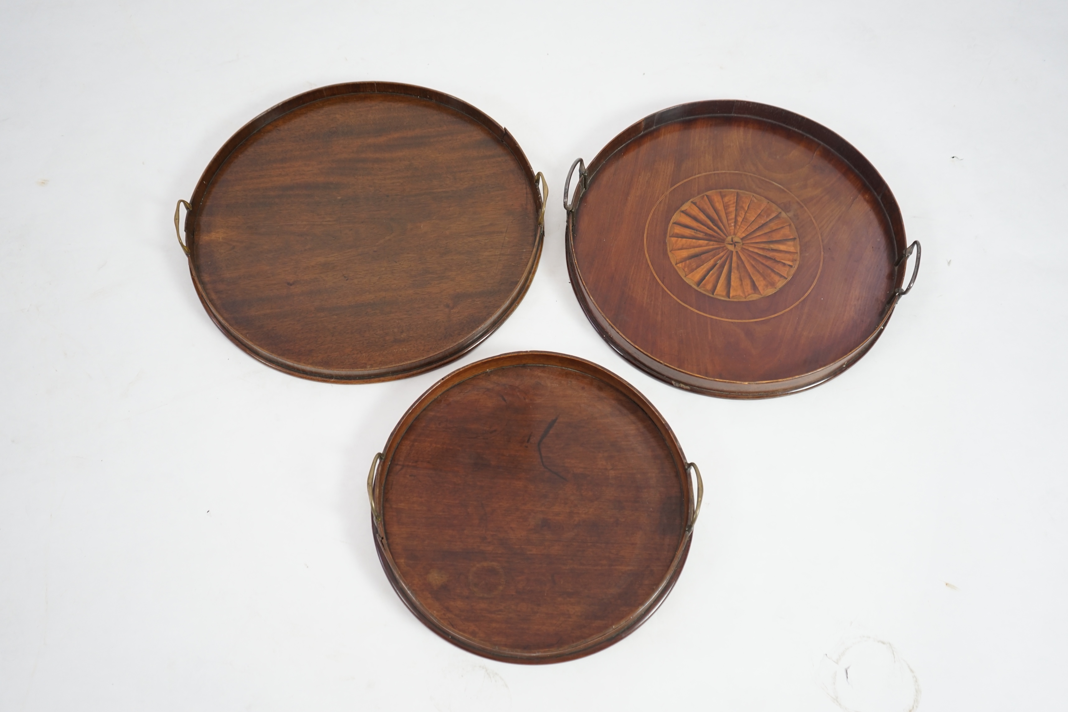 Three George III and later circular mahogany gallery trays